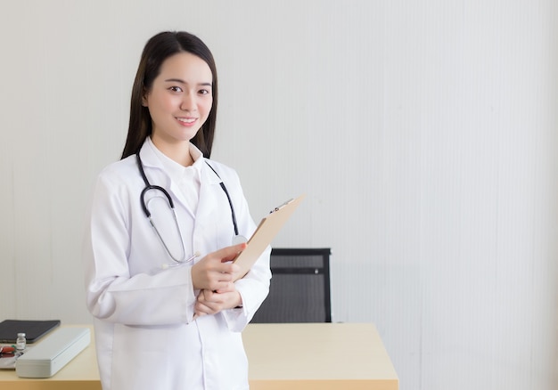 사진 병원에서 일하는 젊고 아름다운 아시아 여성 의사 그녀는 흰 가운과 청진기를 입는다