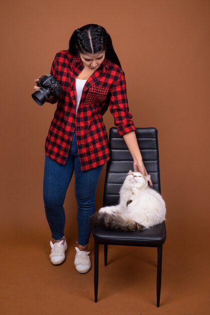 Young beautiful asian woman photographer with persian cat