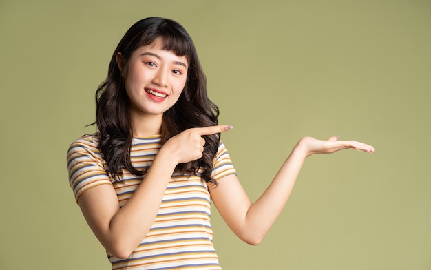 Young beautiful Asian woman posing on beige