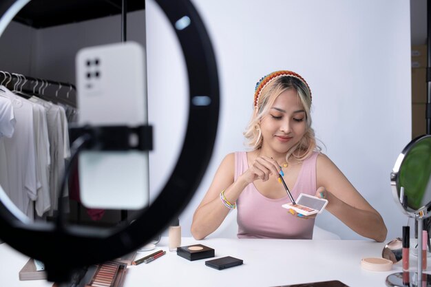 Young beautiful Asian woman and professional beauty make up artist vlogger or blogger recording makeup tutorial to share on website or social media Business online influencer on social media concept