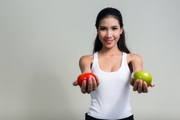 young beautiful Asian woman ready for gym against white space