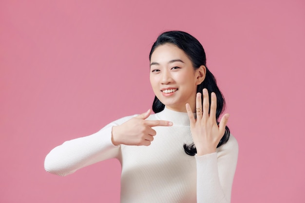 Young beautiful asian woman showing her engagement ring