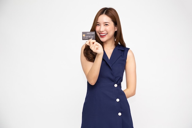 Giovane bella donna asiatica che sorride, mostra, presenta carta di credito isolata su sfondo bianco, modello tailandese