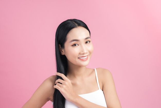 Young beautiful Asian woman taking care of her hair.