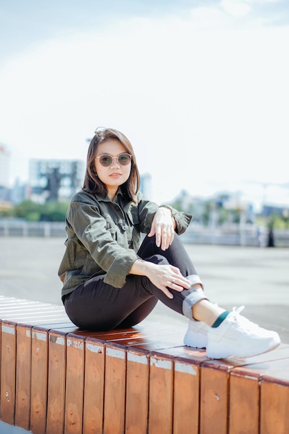 Young Beautiful Asian Woman Wearing Jacket And Black Jeans Posing Outdoors