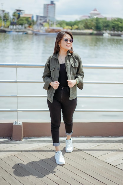 Young Beautiful Asian Woman Wearing Jacket And Black Jeans Posing Outdoors