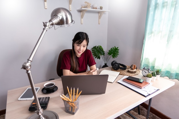 Young beautiful asian woman working at home