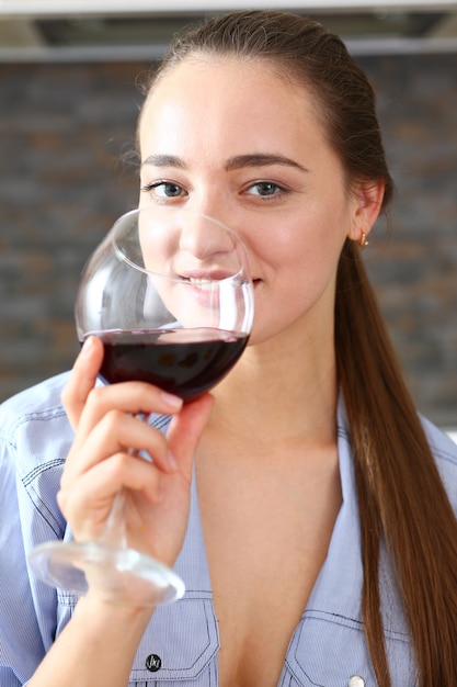 Foto la giovane bella ragazza attraente beve il vino