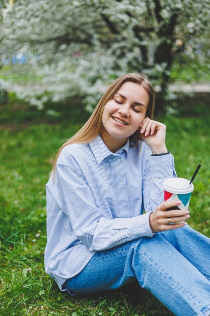 Young beautiful blonde woman in blooming almonds garden