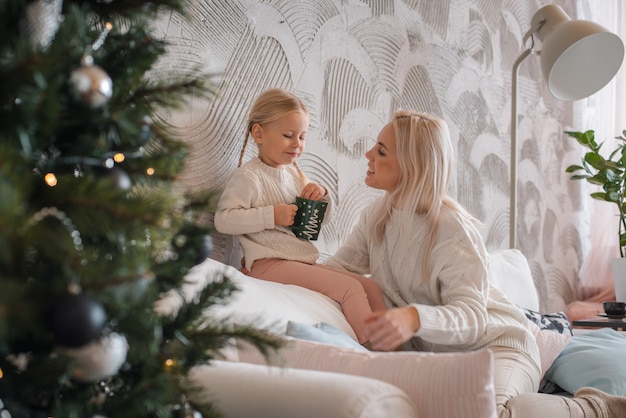 Young beautiful blonde woman hugs her little daughter