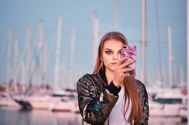 Young beautiful blonde woman taking photos with a smartphone