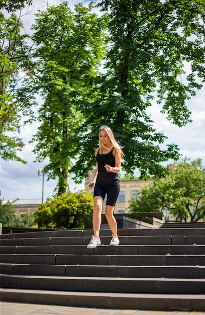 A young beautiful blonde woman with a sporty physique in a black T-shirt 