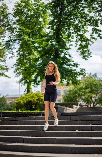 黒のTシャツでスポーティな体格を持つ若い美しいブロンドの女性