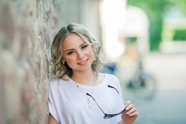 Young beautiful blueeyed blonde in the center of a European city Portrait of a stylish model in casual clothes Happy youth