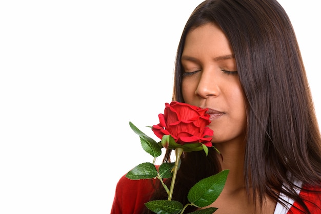 Photo young beautiful brazilian woman smelling red rose