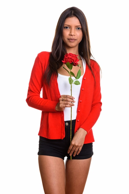 young beautiful Brazilian woman standing while holding a rose