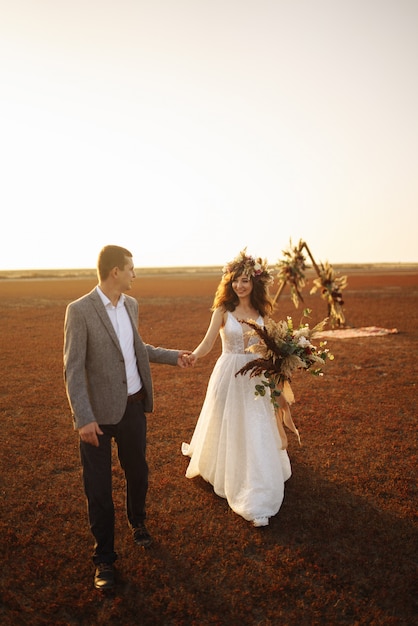 Young and beautiful bride and groom enjoy each other. Wedding day in boho style.