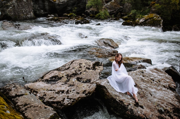 Young beautiful bride in a wedding dress in nature