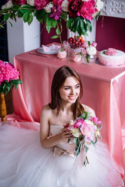 Young beautiful bride with a bouquet of pink peony