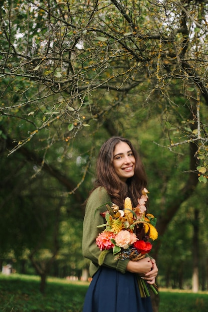 A young beautiful brunette girl with flowers in her hands