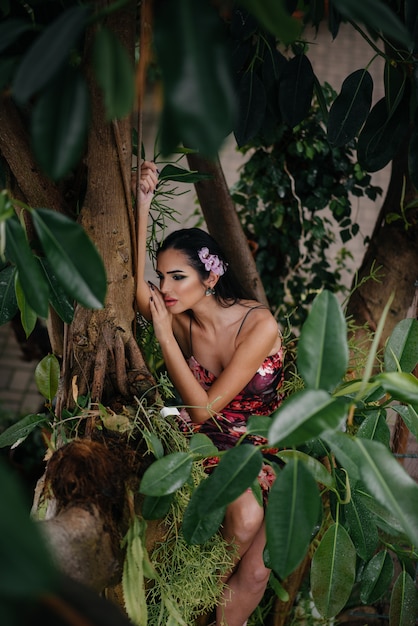 Photo a young beautiful brunette posing among dense thickets of jungle and rainforest. spa