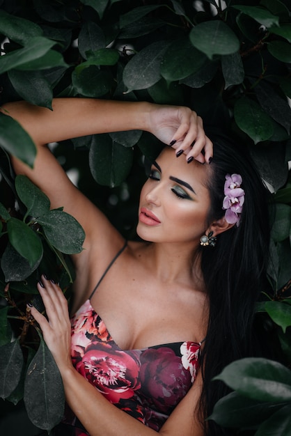 A young beautiful brunette posing among dense thickets of jungle and rainforest. Spa