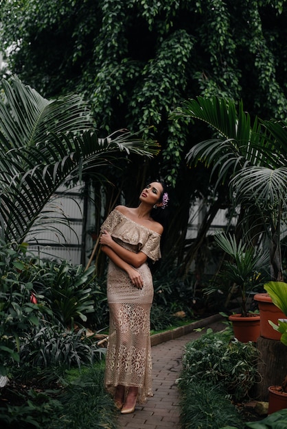 A young beautiful brunette posing among dense thickets of jungle and rainforest. Spa.