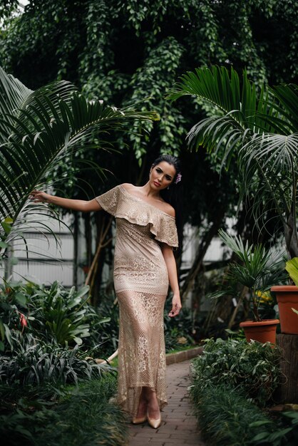 A young beautiful brunette posing among dense thickets of jungle and rainforest.