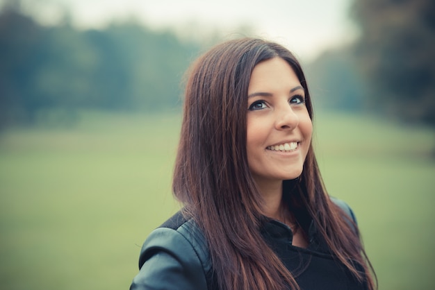 young beautiful brunette straight hair woman in the park 