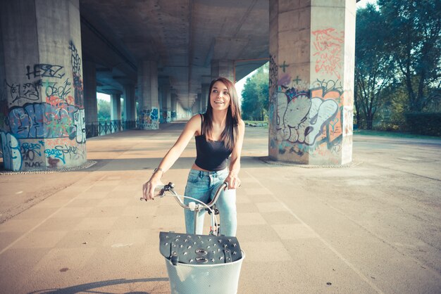 young beautiful brunette straight hair woman using bike