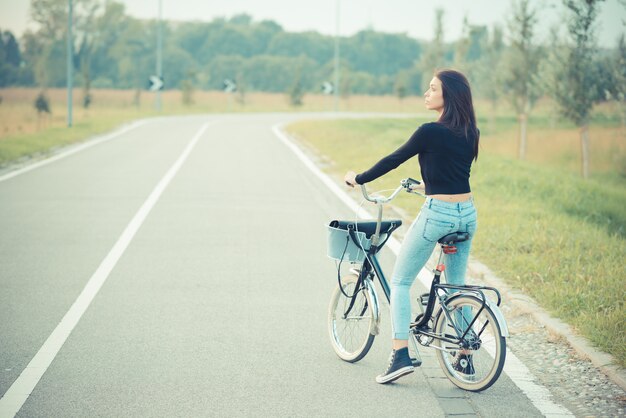 Foto giovane donna bella bruna capelli lisci con bici