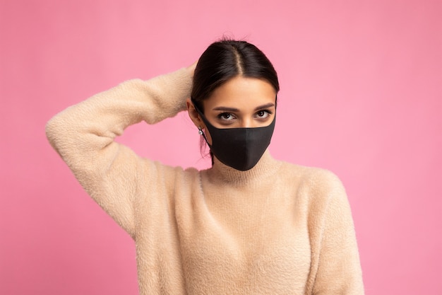 Young beautiful brunette woman in reusable virus protective mask on face