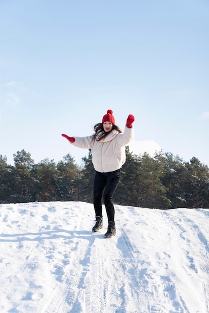 若い美しいブルネットの女性は雪崩からスライドします。冬の晴れた日。垂直フレーム。