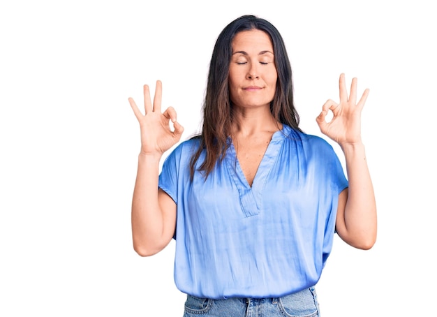 Young beautiful brunette woman wearing casual tshirt relax and smiling with eyes closed doing meditation gesture with fingers yoga concept