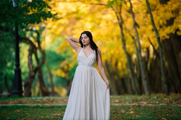 Young beautiful brunette woman in a white dress