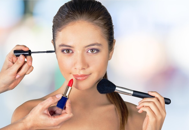 Young beautiful brunette woman with makeup artist