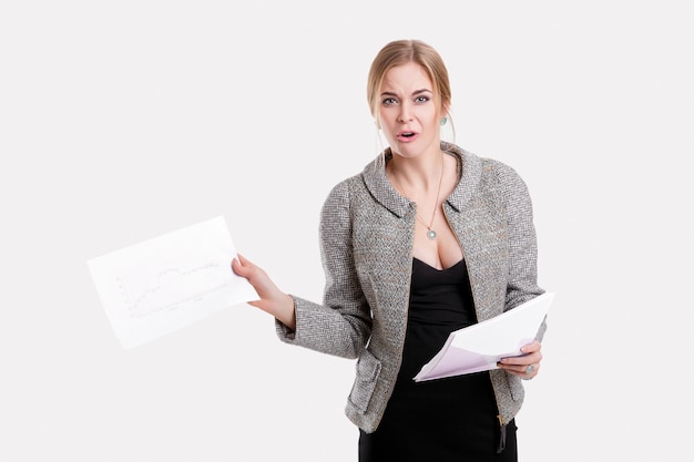 Young beautiful business woman blonde in black dress, jacket holding a folder of papers and smiling on gray background