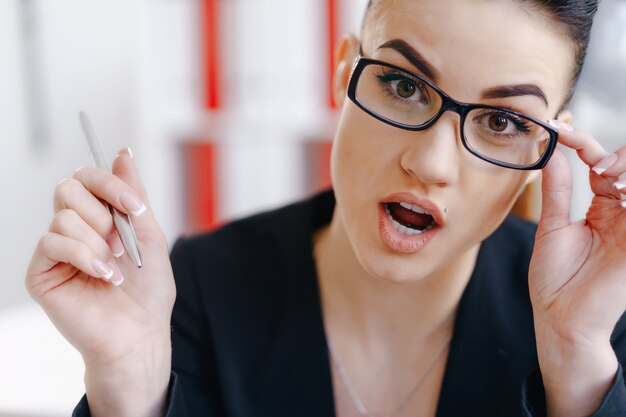 Photo young beautiful business woman holding glasses