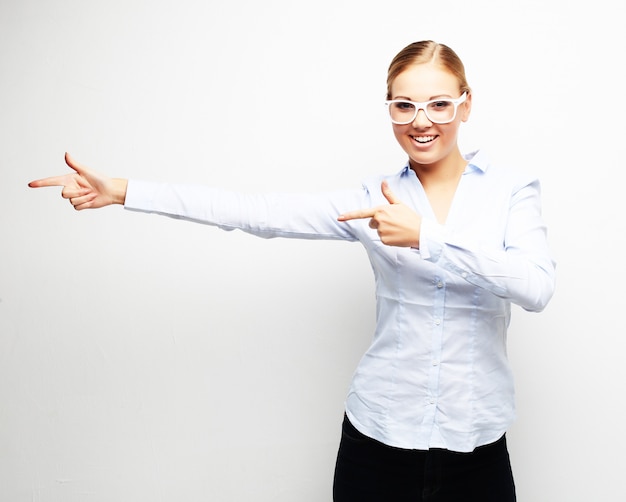 Young beautiful business woman pointing at blank space