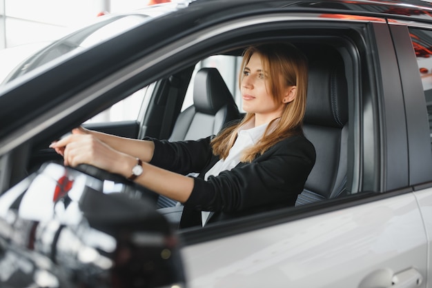 彼女の車に座っている若い美しいビジネス女性