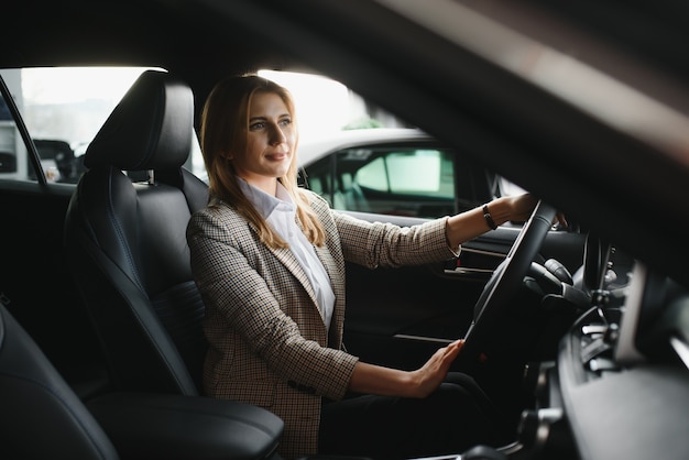 彼女の車に座っている若い美しいビジネス女性