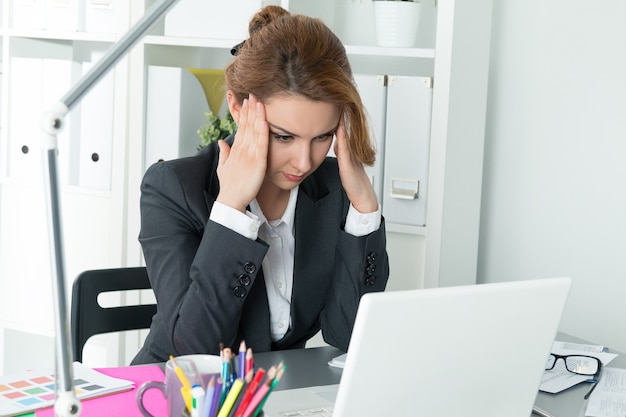 Young beautiful business woman trying to concentrate looking at laptop monitor