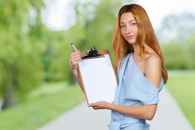 Young beautiful business woman with clipboard