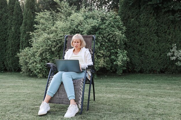 Young beautiful business woman working on a laptop freelancer works in nature Businesswoman At Work Outdoors
