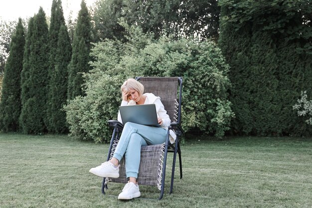 Photo young beautiful business woman working on a laptop freelancer works in nature