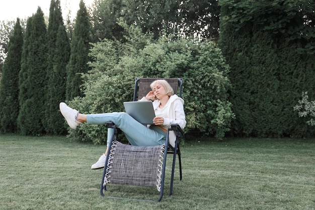 Young beautiful business woman working on a laptop freelancer works in nature