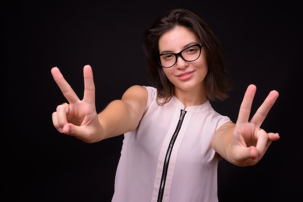  young beautiful businesswoman against black wall