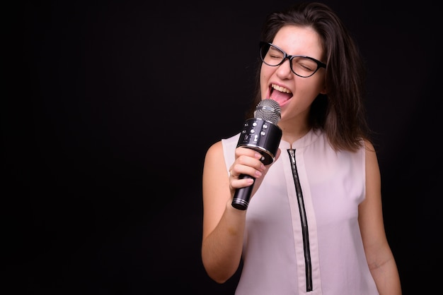 Photo young beautiful businesswoman against black wall