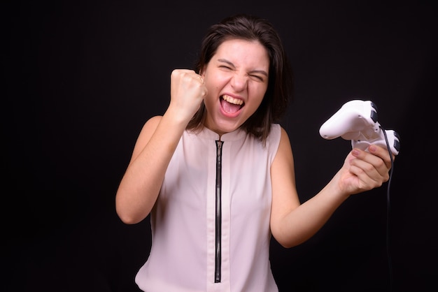 young beautiful businesswoman against black wall