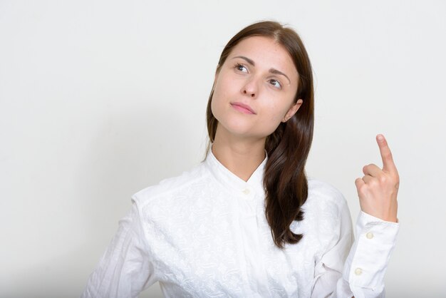 young beautiful businesswoman against white wall